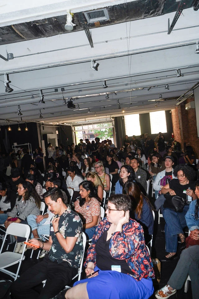 Guests watch a Future of NYC Design presentation from the audience.